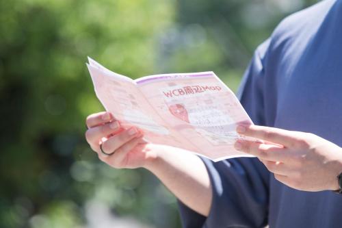 a person holding a newspaper in their hands at Wild Cherry Blossom-HOSTEL,TOKYO KOGANEI- in Koganei