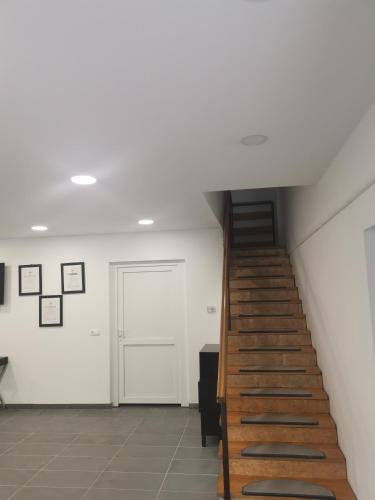 a staircase in a room with white walls and wooden stairs at Podlovics Tanya Panzió in Kemecse