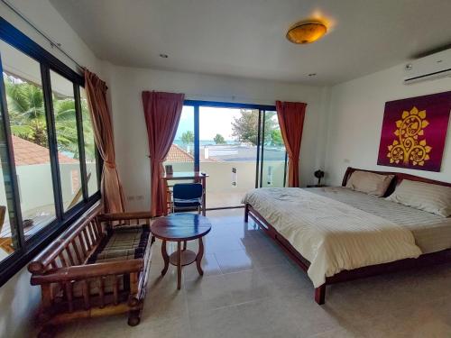 una camera da letto con un letto, un tavolo e una finestra di Heaven Beach Koh Samui a Laem Sor