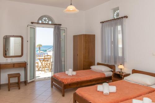 ein Hotelzimmer mit 2 Betten und einem Balkon in der Unterkunft Esperides in Tinos
