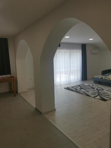 an archway in a room with a bed and a table at Podlovics Tanya Panzió in Kemecse