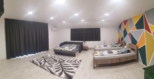 a room with two beds and a rug at Podlovics Tanya Panzió in Kemecse
