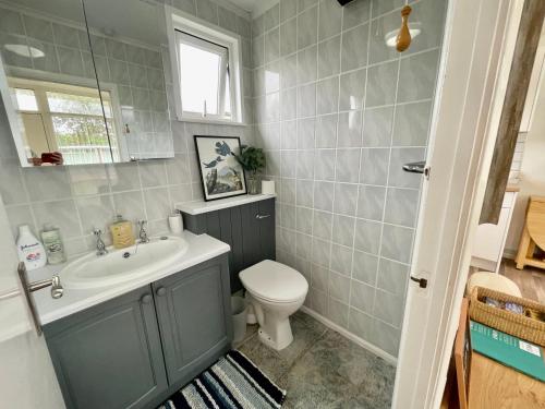 a bathroom with a sink and a toilet at 197 Broadside Holiday Chalet near Broads & Beaches in Stalham