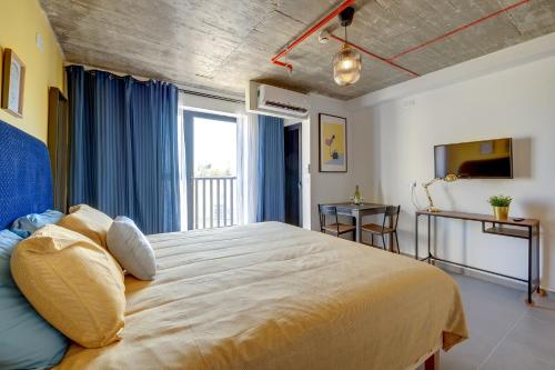 a bedroom with a large bed with blue curtains at Sliema Creek Suites in Sliema