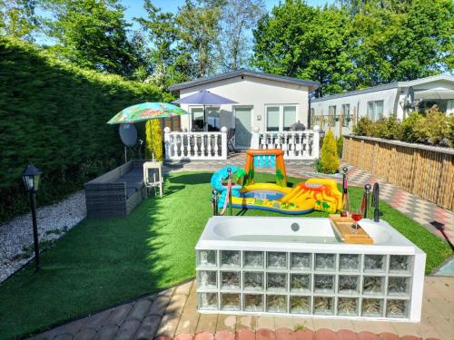 a backyard with a play area with a sink and an umbrella at Villa Blue Sky in Heinkensand