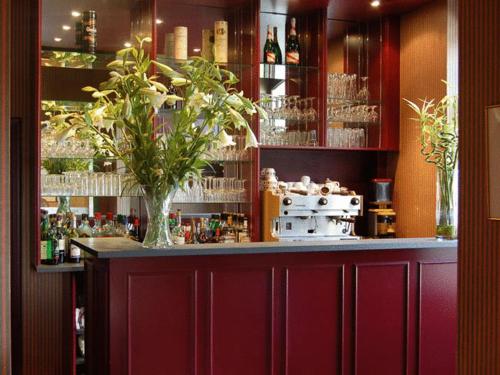 a bar with a vase of flowers on a counter at Guesthouse Les Tilleuls in Fleurus