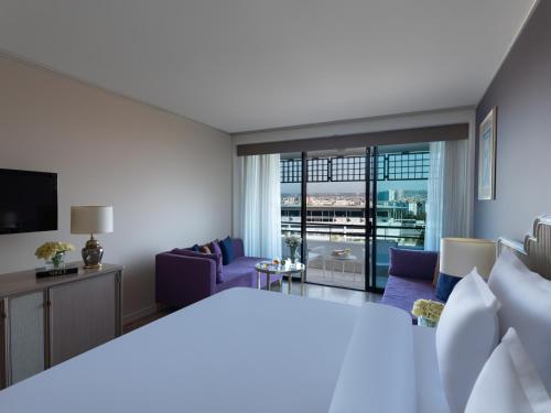 a hotel room with a bed and a living room at Rixos Downtown Antalya - The Land Of Legends Access in Antalya