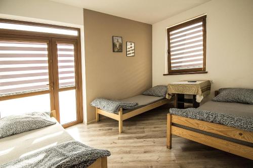 a room with three beds and a window at Aris Pokoje Gościnne in Wojnicz