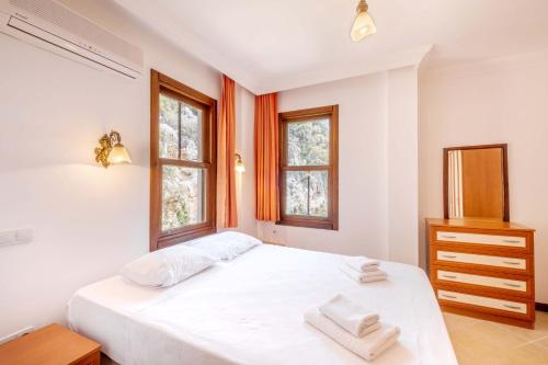una camera da letto bianca con un letto e due finestre di Kybele Sea view a Kaş