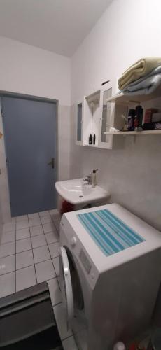 a bathroom with a sink and a washing machine at Apartment Pijer in Novalja