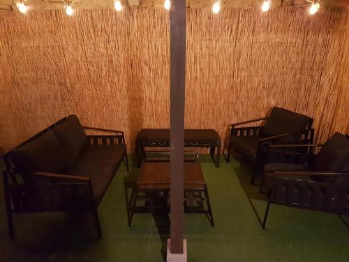 un groupe de chaises et de tables dans une pièce dans l'établissement LA MAISON DE LOLA, à Port-en-Bessin-Huppain