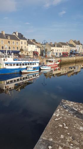 a group of boats docked in a harbor with buildings at LA MAISON DE LOLA in Port-en-Bessin-Huppain