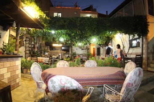 a table and chairs in a garden at night at Tuncay Pension in Selcuk