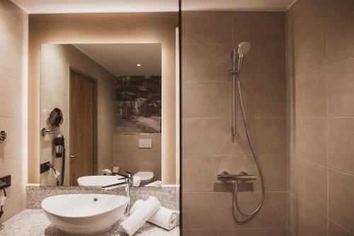 a bathroom with a sink and a shower at Das Steinmüller Hotel in Gummersbach