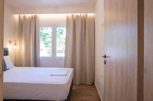 a small bedroom with a bed and a window at Elena luxury living in Paralía Skotínis