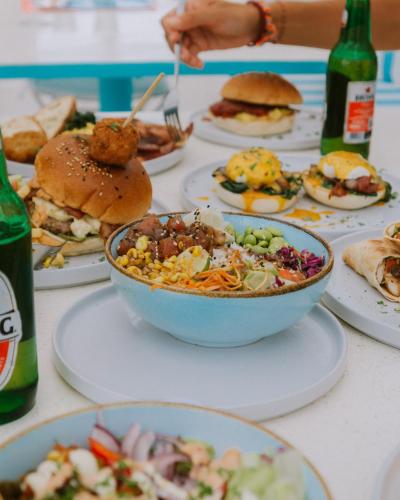 a table with a bowl of food and plates of food at Mad Monkey Kuta Lombok in Kuta Lombok