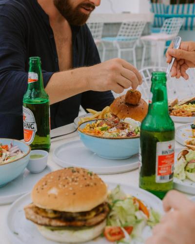a table with plates of food and bottles of beer at Mad Monkey Kuta Lombok in Kuta Lombok