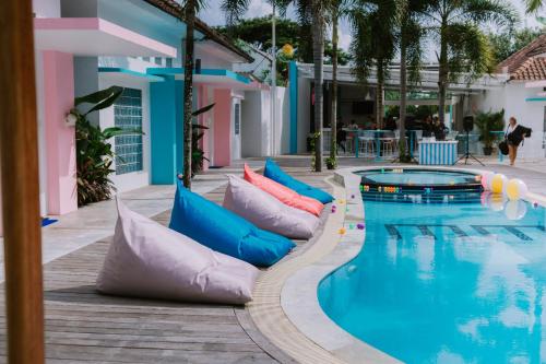 a pool with inflatable pillows next to a resort at Mad Monkey Kuta Lombok in Kuta Lombok