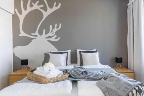 a bedroom with a bed with a reindeer stenciled wall at Arctic Railway City Suite in Rovaniemi