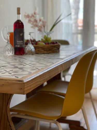 a table with a bottle of wine and two chairs at Cosy Apartment With Sea View Close To The Beach in Nikiana