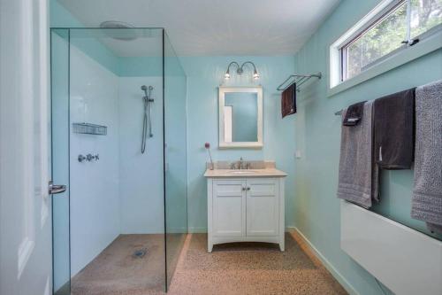 a bathroom with a glass shower and a sink at The CoachHouse in Main Ridge
