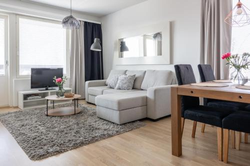 a living room with a white couch and a table at Arctic Railway City Suite in Rovaniemi