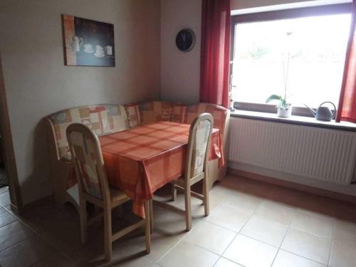 een eettafel en stoelen in een kamer met een raam bij Ferienwohnung Hilde Schneider in Kappeln