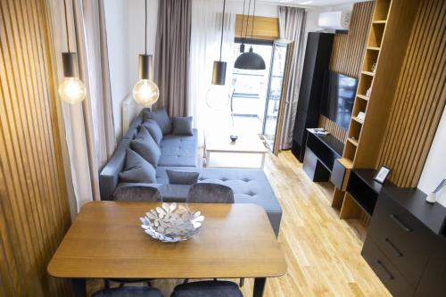 una sala de estar con una mesa y un sofá en President Apartman 5, en Vračar (historical)