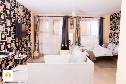 uma sala de estar com dois sofás brancos e um sofá em Lux Suites City View Studio Apartments Ngara em Nairobi