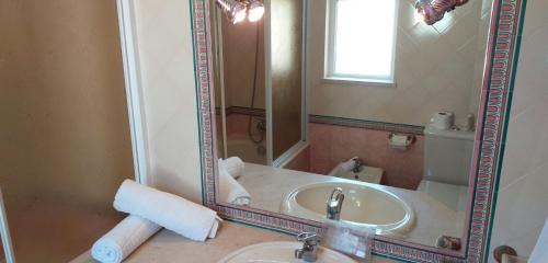 a bathroom with a sink and a mirror at Vila Rosada in Quarteira