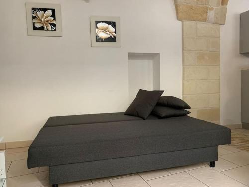 a bed in a room with two pictures on the wall at LA PICCOLA DIMORA in Carovigno