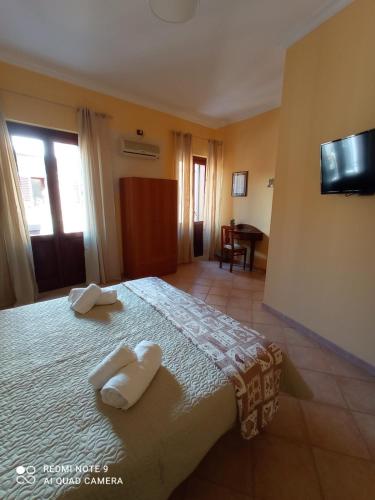 a bedroom with a bed with two towels on it at La sinfonia di.kerkent in Agrigento