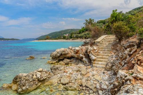 a set of stairs on a rocky shore next to the ocean at Villa Thilia in Meganisi