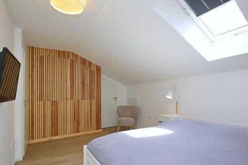 - une chambre avec un lit, une chaise et une fenêtre dans l'établissement Strandvilla Meeresblick Wohnung 07, à Boltenhagen