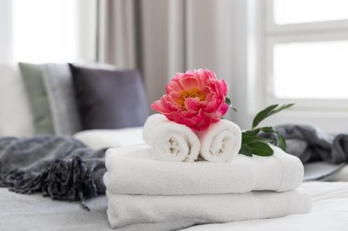 una pila de toallas con una flor en una mesa en Arctic Penthouse City Suite en Rovaniemi