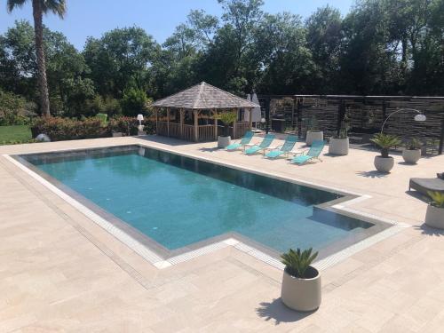 a swimming pool with chairs and a gazebo at Luxury Zen in Châteauneuf