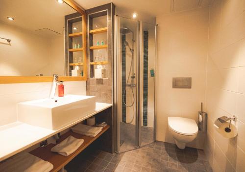 uma casa de banho com um lavatório, um chuveiro e um WC. em Spahotel Casino em Savonlinna