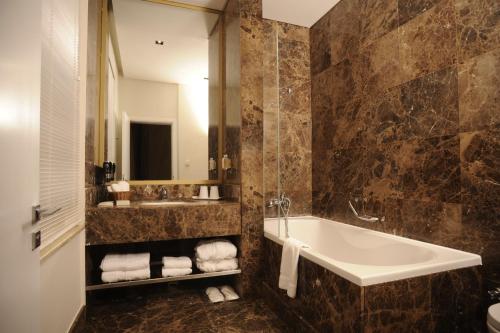 伊斯坦堡的住宿－伊斯坦布爾彌撒菲爾8號套房酒店，带浴缸、水槽和镜子的浴室
