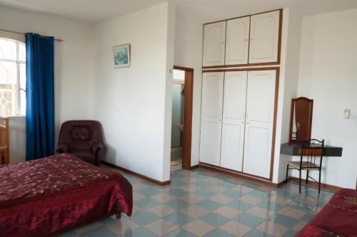 ein Schlafzimmer mit einem Bett und einem großen Schrank in der Unterkunft The Impala Mauritius Bed & Breakfast in Trou aux Biches