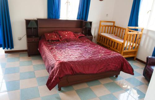 特魯歐克比赫斯的住宿－The Impala Mauritius Bed & Breakfast，一间卧室配有一张床、一把椅子和蓝色窗帘