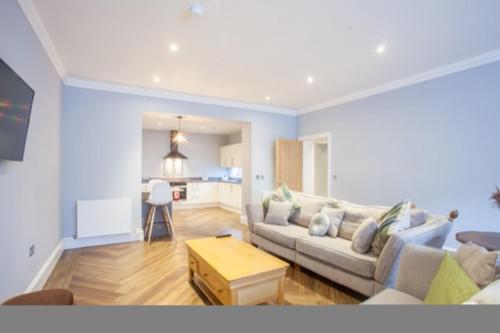 a living room with a couch and a table at Stylish 2 Bedroom Apartment In Park Circus, West End in Glasgow