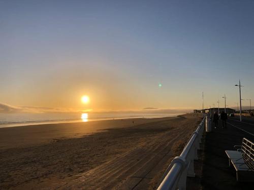 a beach with the sun rising over the ocean w obiekcie 10 Minutes Walk To The Beach w mieście Port Talbot