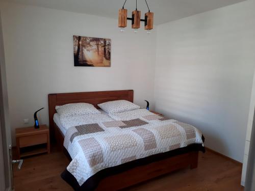 ein Schlafzimmer mit einem Bett und einem Bild an der Wand in der Unterkunft Mýto apartments in Mýto pod Ďumbierom