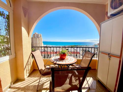a balcony with a table and chairs and a view of the ocean at Beautiful apartment near LaMata Beach with PANORAMA SEA view!!! in Torrevieja