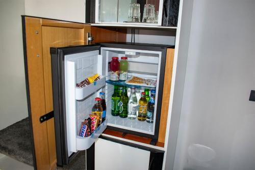 an open refrigerator filled with lots of drinks at La Conacul Vesel Săpânța in Săpînţa