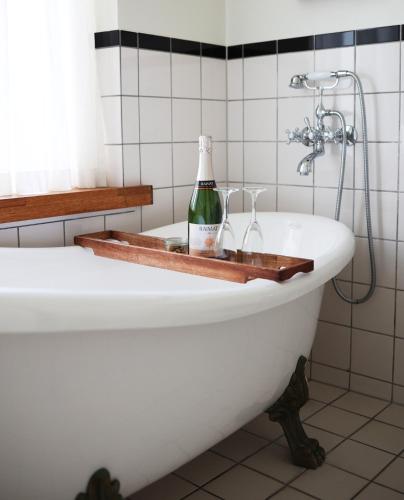 a bathroom with a bottle of wine on a bath tub at SOFS boutique hotel in Aarhus