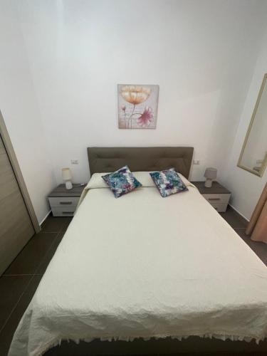 um quarto com uma cama com duas almofadas em Stella Marina em La Caletta