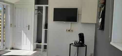 a living room with a tv on a wall at 't Bûtefjild in De Broek