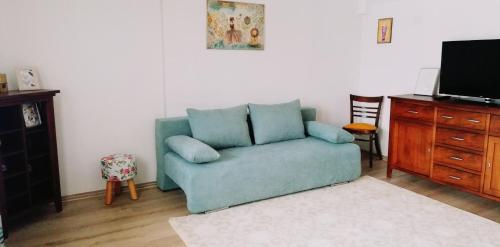 a living room with a blue couch and a tv at Vila Chic M in Moieciu de Jos