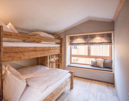 a bedroom with two bunk beds and a window at Alpegg Chalets in Waidring